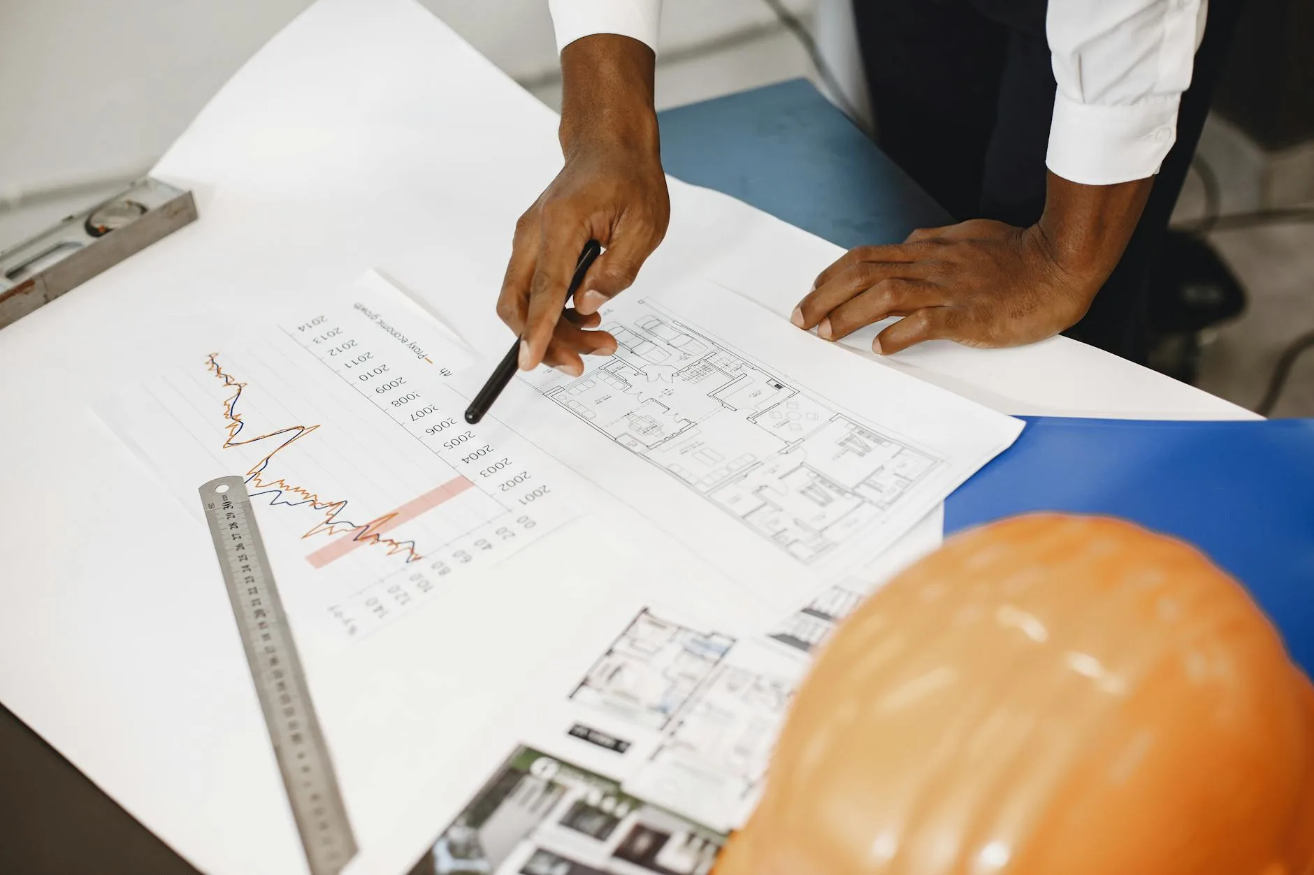 Architekt analizuje projekt budowlany i wykresy kosztów na biurku