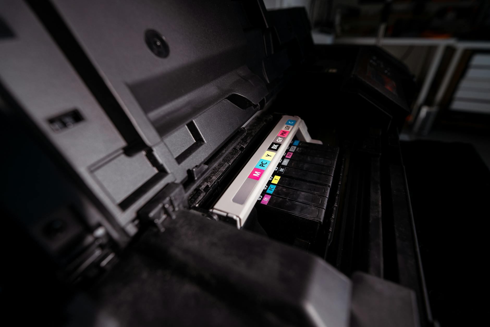 Otwarta drukarka biurowa z widocznymi kolorowymi tuszami CMYK